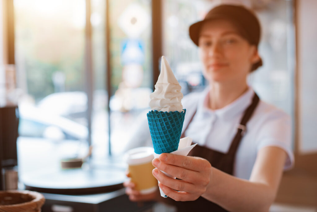 female-seller-holds-cone-with-twisted-ice-cream-from-vending-machine-her-hand-small-business-takeaway-food-summer-food-cool-off-heat